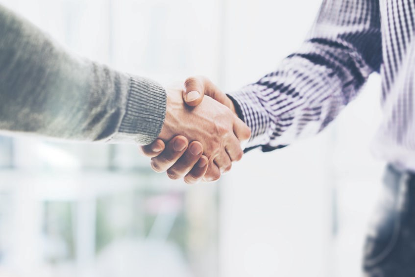 Two people shaking hands after a sale.